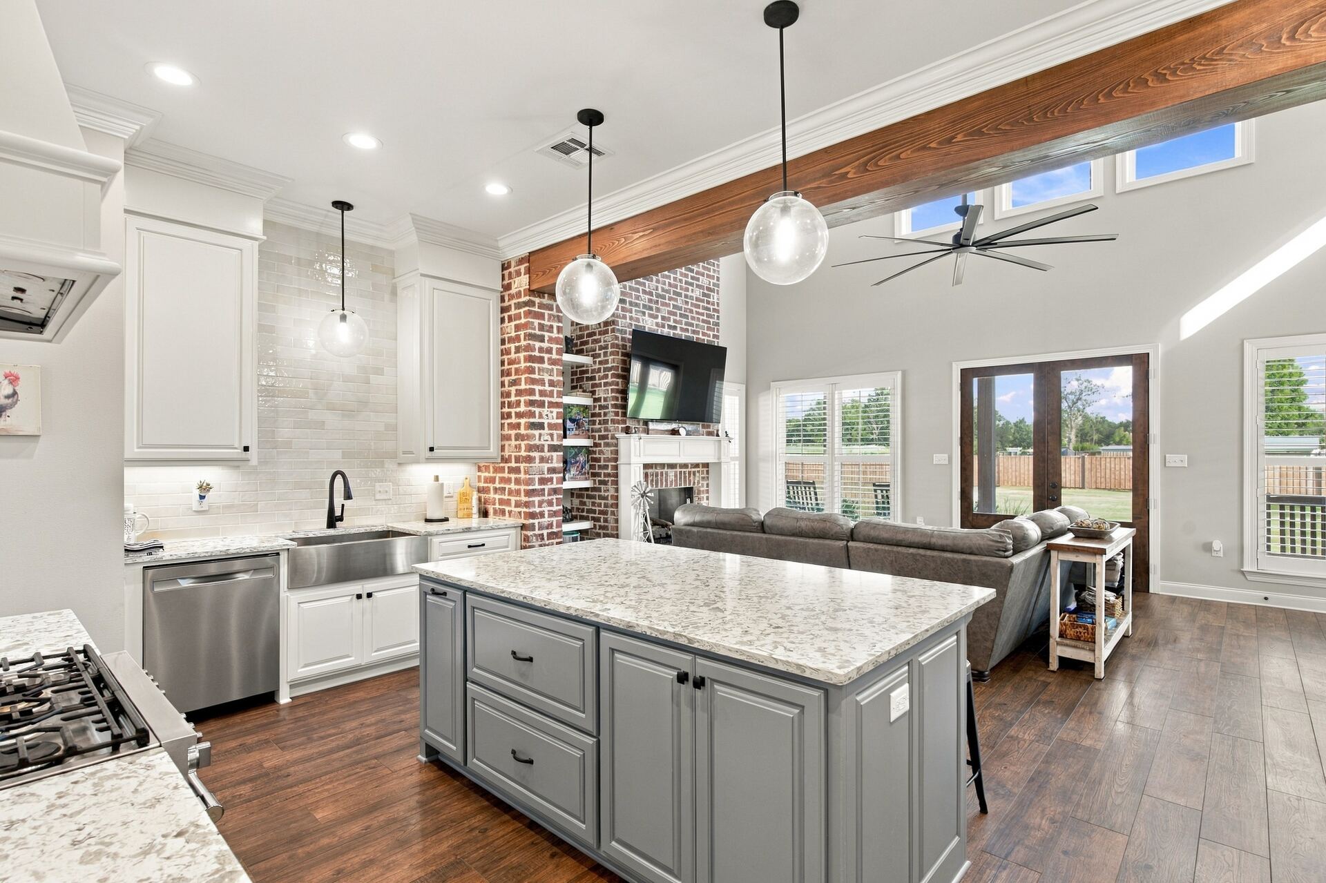 Kitchen with granite island, pendant lighting and exposed brick