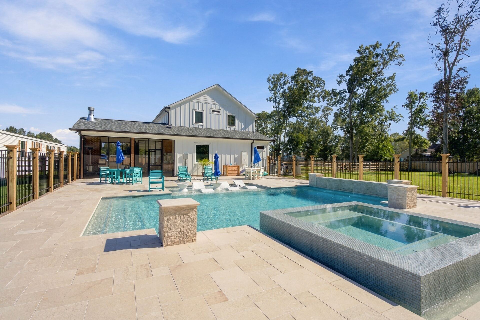 Swimming pool, spa and rear elevation of the farmhouse at midday
